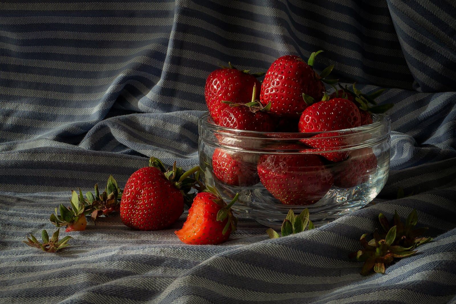 A still life of strawberries in a glass bowl